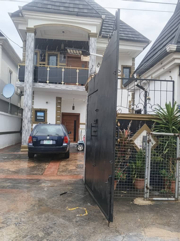 Duplex viewed through an open gate with potted plants