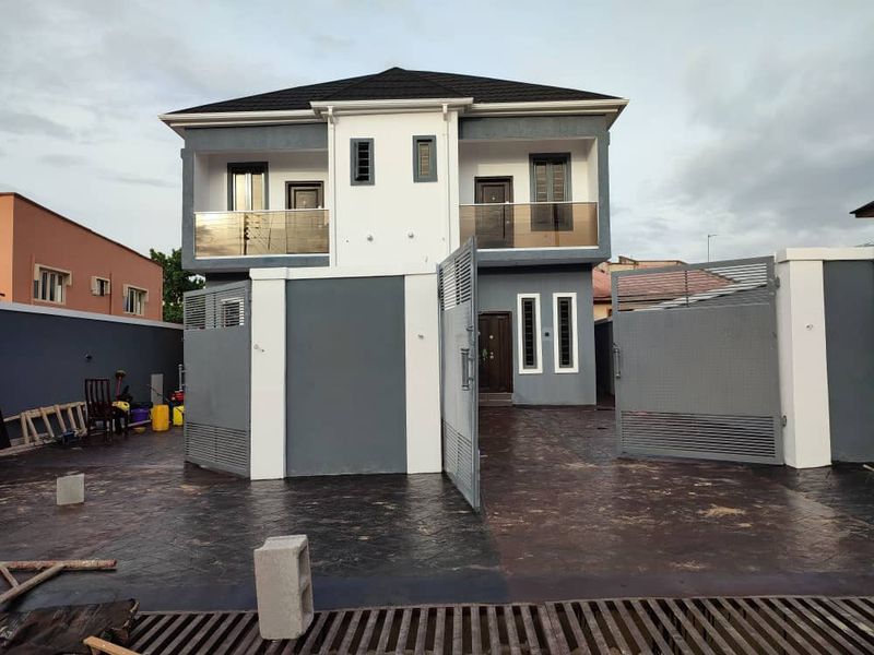 Grey and white duplex with balconies and a stamped concrete forecourt