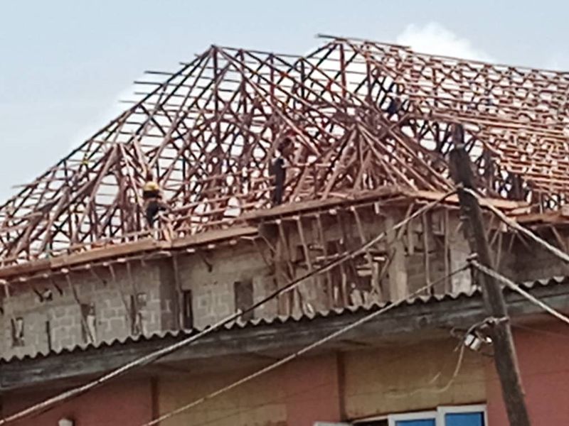 Timber roof trusses being fixed on a block building